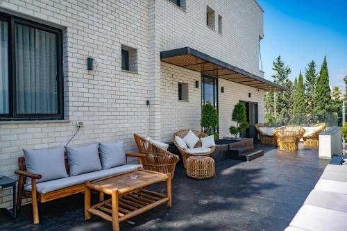 特拉维夫Rokah Luxury Villa at Ramat HaHayal的一个带沙发和椅子的庭院和一座建筑