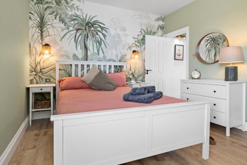 朴次茅斯Cosy & Bright Home with Backyard in Southsea Portsmouth的卧室配有白色床和粉红色枕头