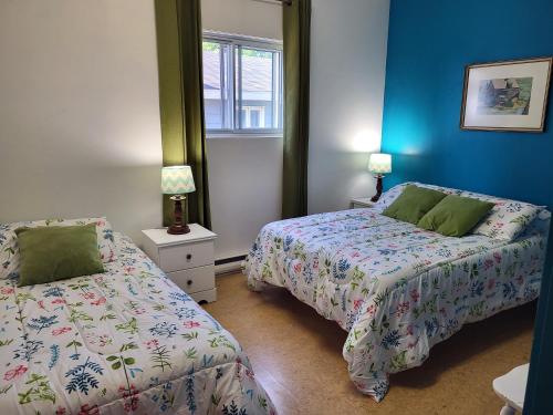 博纳旺蒂尔Auberge Soleil de Mer的卧室设有两张床铺和蓝色的墙壁