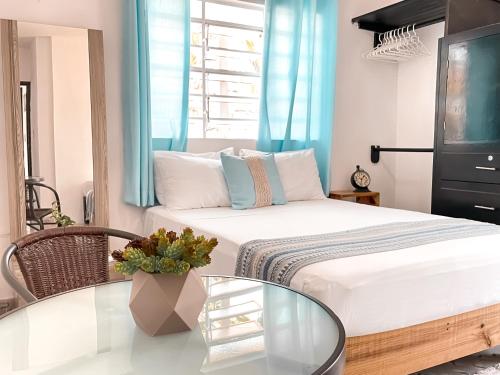 巴卡拉尔Casa Momo Bacalar的一间卧室配有一张床和一张玻璃桌