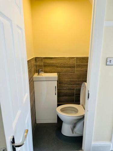 伍德福德格林4 Bed Family Home的浴室配有白色卫生间和盥洗盆。