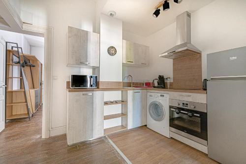 里摩日Le pied à terre d'ernest的厨房配有白色橱柜、洗衣机和烘干机