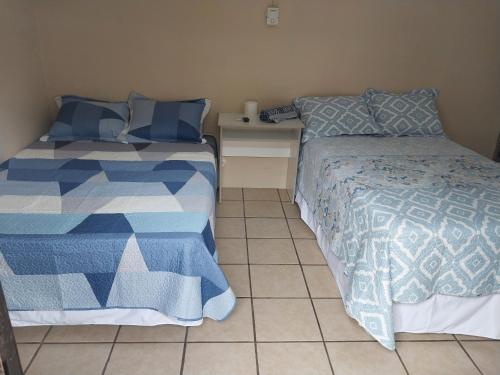 拉乌尼翁Hostal San José的一间带两张床的卧室,铺有瓷砖地板。
