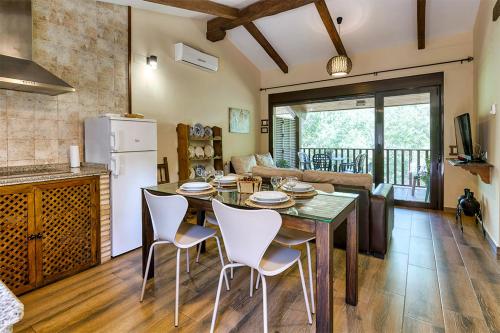 埃尔托尔诺Apartamentos rurales Alameda del Jerte的厨房以及带桌椅的起居室。