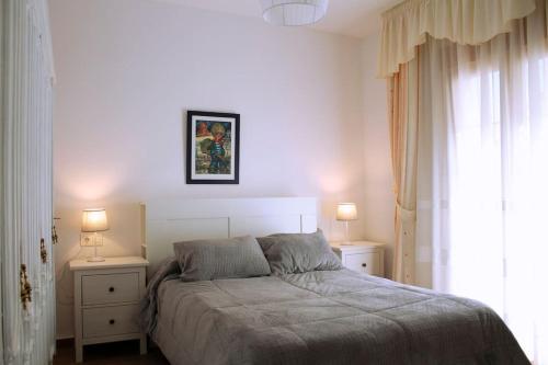 SoportújarEl escondite de Hansel y Gretel的一间卧室配有一张带2个床头柜和2盏灯的床。