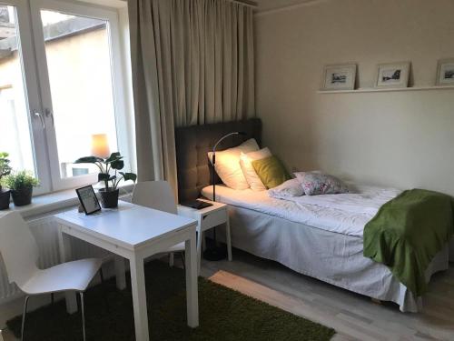 赫尔辛堡Lilla Drottninggatan Apartment Hotel的一间卧室配有一张床、一张桌子和一张书桌