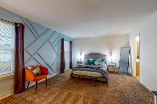 FruitlandThe Garrison Getaway的一间卧室配有一张特大号床和一把椅子