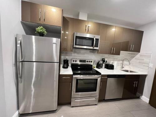费城305 Cozy and lovely 1BDR apartment in Center City的厨房配有不锈钢冰箱和微波炉。