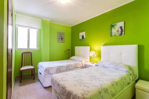 卡耐特蒂贝兰格Vacaciones Canet Playa - en primera linea的绿色卧室配有两张床和椅子