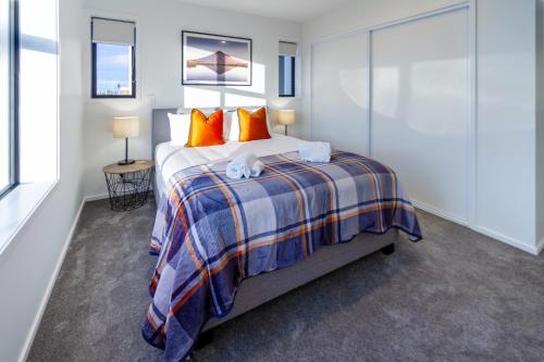 基督城3 bedroom 2 bath Central City的一间卧室配有一张带橙色枕头的大床