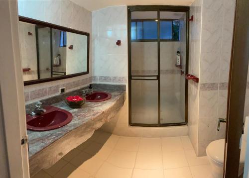 吉拉尔多特El Peñón, Girardot-Colombia的一间带两个盥洗盆和淋浴的浴室