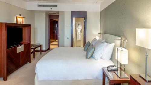 波尔图波尔图皇冠假日酒店的卧室配有一张白色大床和电视。