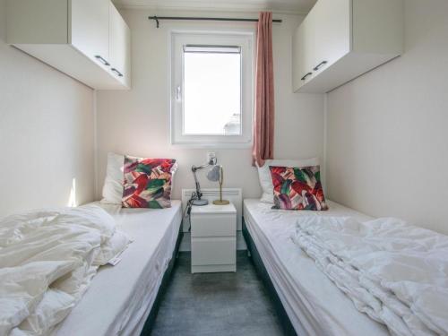布勒克伦Grote Karekiet 24-22的一间卧室设有两张床和窗户。