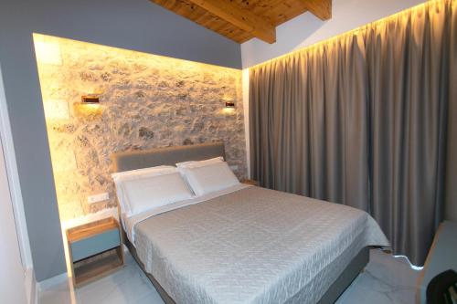 帕尔加Elais Luxury Villas的一间卧室设有一张床和石墙