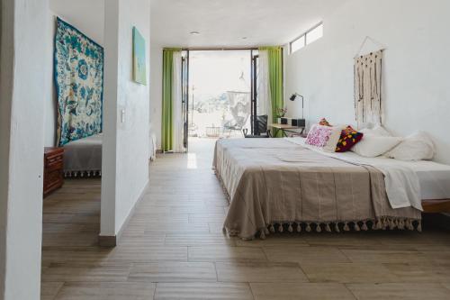 萨尤利塔Casa Fenix的一间卧室设有一张大床和一个大窗户