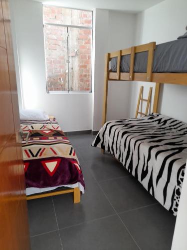 卢那欢纳Casa de Campo Las Tujas的一间卧室设有两张床和窗户。