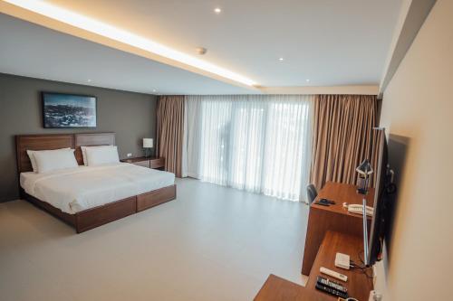 马比尼Solitude Acacia Resort的一间卧室配有一张床、一张书桌和一台电视