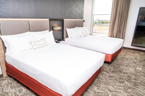 安大略SpringHill Suites by Marriott Ontario Airport/Rancho Cucamonga的酒店客房设有两张床和窗户。