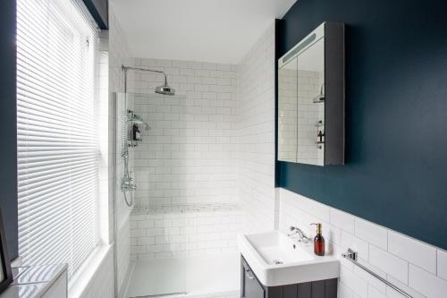 伦敦Eden Grove - Islington - Studio Apartment的白色的浴室设有水槽和淋浴。