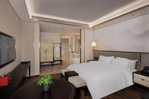 杭州杭州君尚云郦酒店的卧室配有一张白色的大床和一张桌子