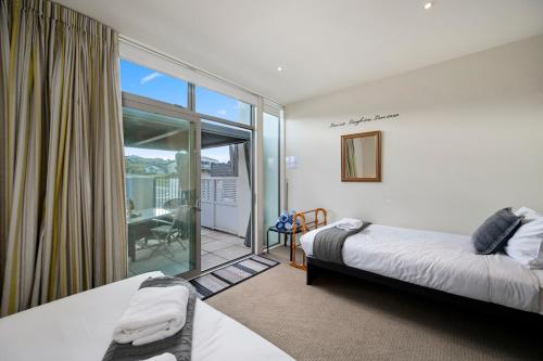 陶波Marina View Apartment - Taupo的一间带两张床的卧室和一个阳台