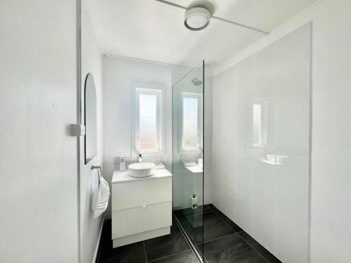 汤斯维尔Townsville Suites的白色的浴室设有水槽和镜子