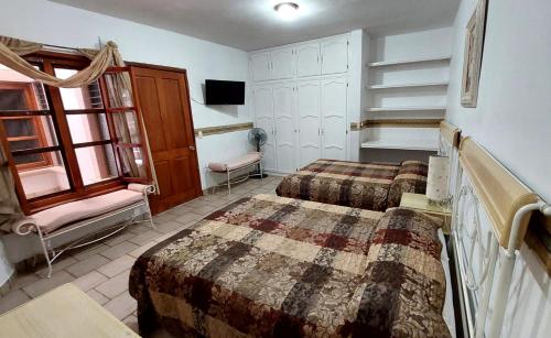 Calera Víctor RosalesHotel Morada de los Angeles的一间酒店客房,设有两张床和电视