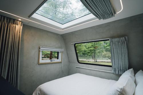 冬山乡天ㄟ露營車的一间卧室配有一张床和天窗