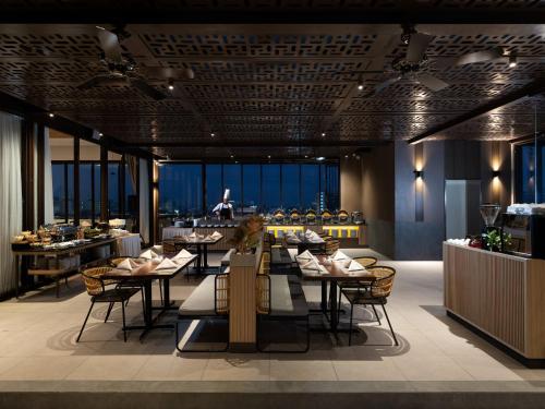 万隆Hotel Santika PasirKaliki的一间带桌椅的餐厅和一间酒吧