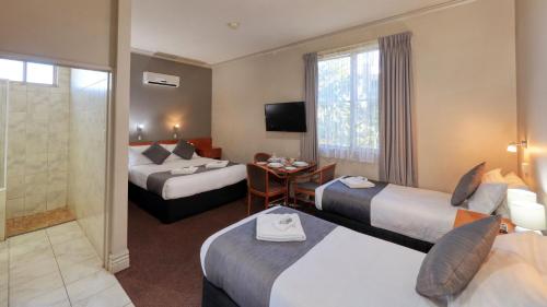 布罗肯希尔银黑文汽车旅馆的酒店客房设有两张床和一张桌子。