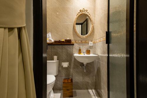 乌布Tigata Ubud Cottage的一间带卫生间、水槽和镜子的浴室