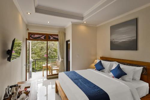 乌布Tigata Ubud Cottage的一间带大床的卧室和一个阳台