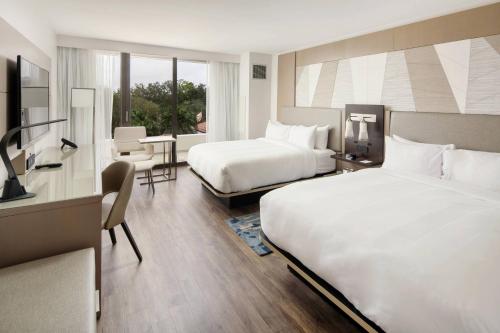 棕榈滩花园棕榈滩花园万豪酒店的酒店客房设有两张床和一张桌子。