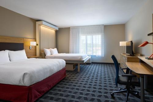 西哥伦比亚TownePlace Suites By Marriott Columbia West/Lexington的酒店客房配有两张床和一张书桌