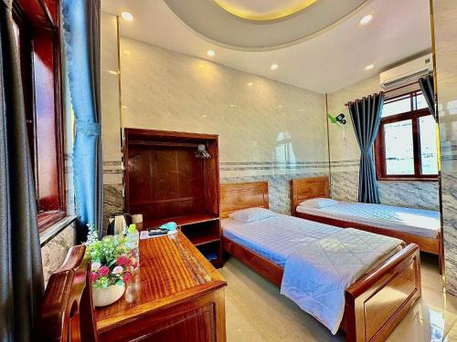 朔庄Khách sạn Vĩnh Chương的一间卧室配有两张床和一张鲜花桌