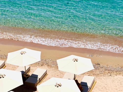 克拉尼WHITE DONKEY Hotel的海滩上的一组白色遮阳伞