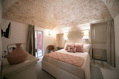 阿尔贝罗贝洛San Marco Boutique Rooms的卧室配有白色的床和砖墙
