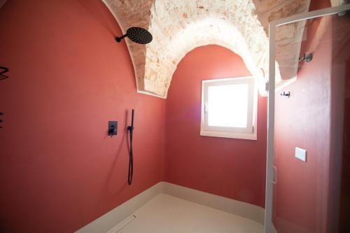 阿尔贝罗贝洛San Marco Boutique Rooms的浴室设有红色的墙壁和带窗户的淋浴