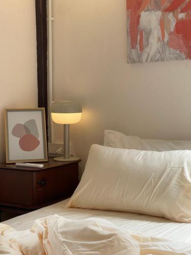 素叻The Ordinary 8的一间卧室配有一张带灯和照片的床