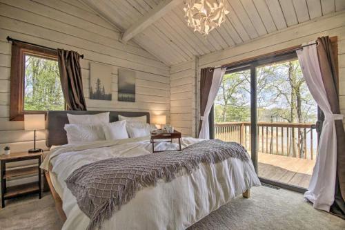 埃尔克顿Cozy Winter Cabin Retreat with View的一间卧室配有一张床,阳台配有吊灯。