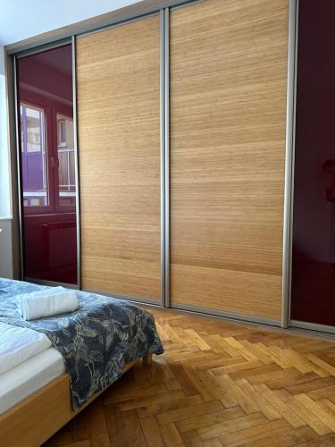 格丁尼亚Apartament Syrokomli 3的一间卧室设有大衣柜,铺有木地板