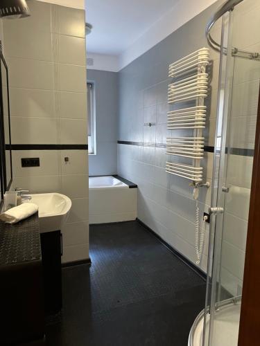 格丁尼亚Apartament Syrokomli 3的带淋浴、盥洗盆和浴缸的浴室
