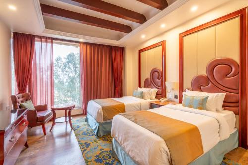 赖布尔Hukam's Lalit Mahal的酒店客房设有两张床和窗户。
