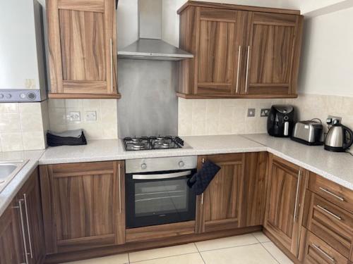 利物浦Marks Place的厨房配有木制橱柜和炉灶烤箱。