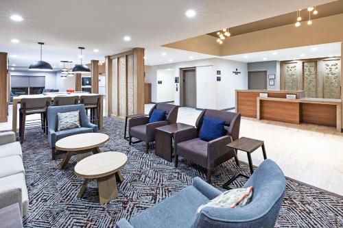 欧文Candlewood Suites DFW Airport North - Irving, an IHG Hotel的一间设有桌椅的等候室和一间酒吧