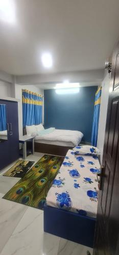 ThimiHotel Homestay Inn的一间设有两张床和蓝色墙壁的客房