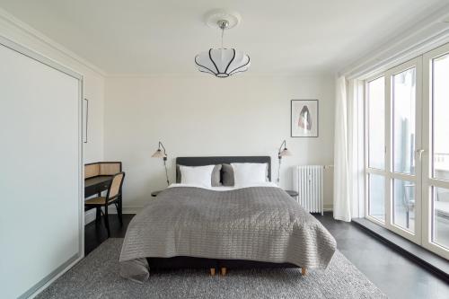 哥本哈根Beautiful 3 Bedroom Flat Near Shopping & Metro的卧室配有床、桌子和窗户。