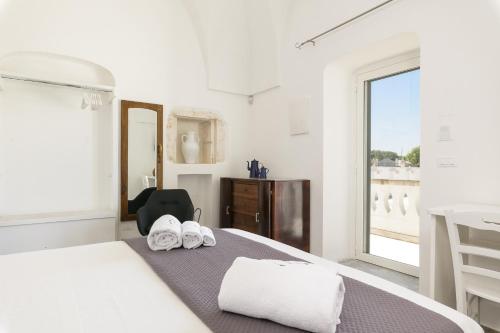 奥斯图尼Masseria Abadia Uno的白色的卧室设有床和窗户