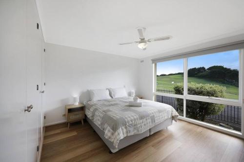 沃纳姆堡Logans Beach Apartments - Greenviews的白色的卧室设有床和大窗户