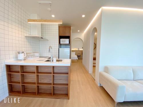 釜山Paul Mare Pool Villa的一个带水槽的厨房和一张沙发